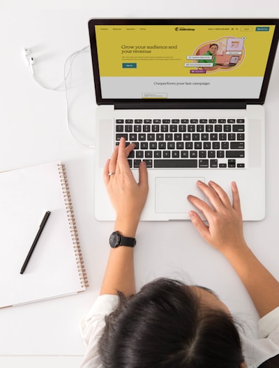 a person sitting at a desk with a laptop and a coffee cup