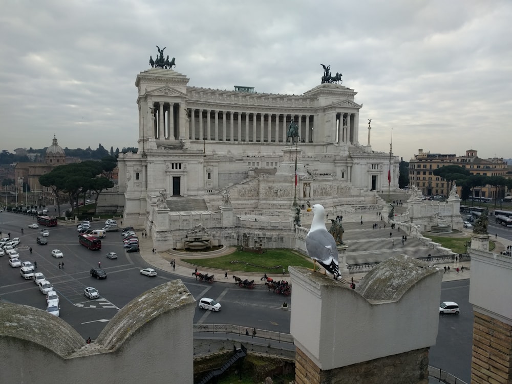 a large stone building with a statue in front of it with Piazza Venezia in the background