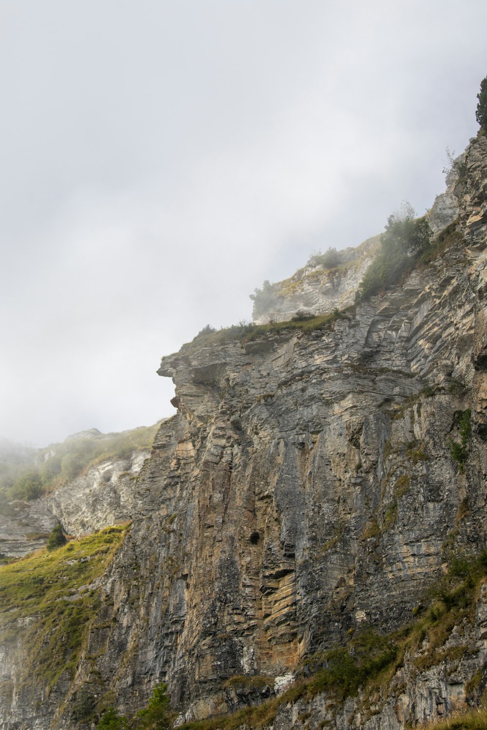 a rocky cliff with a valley below