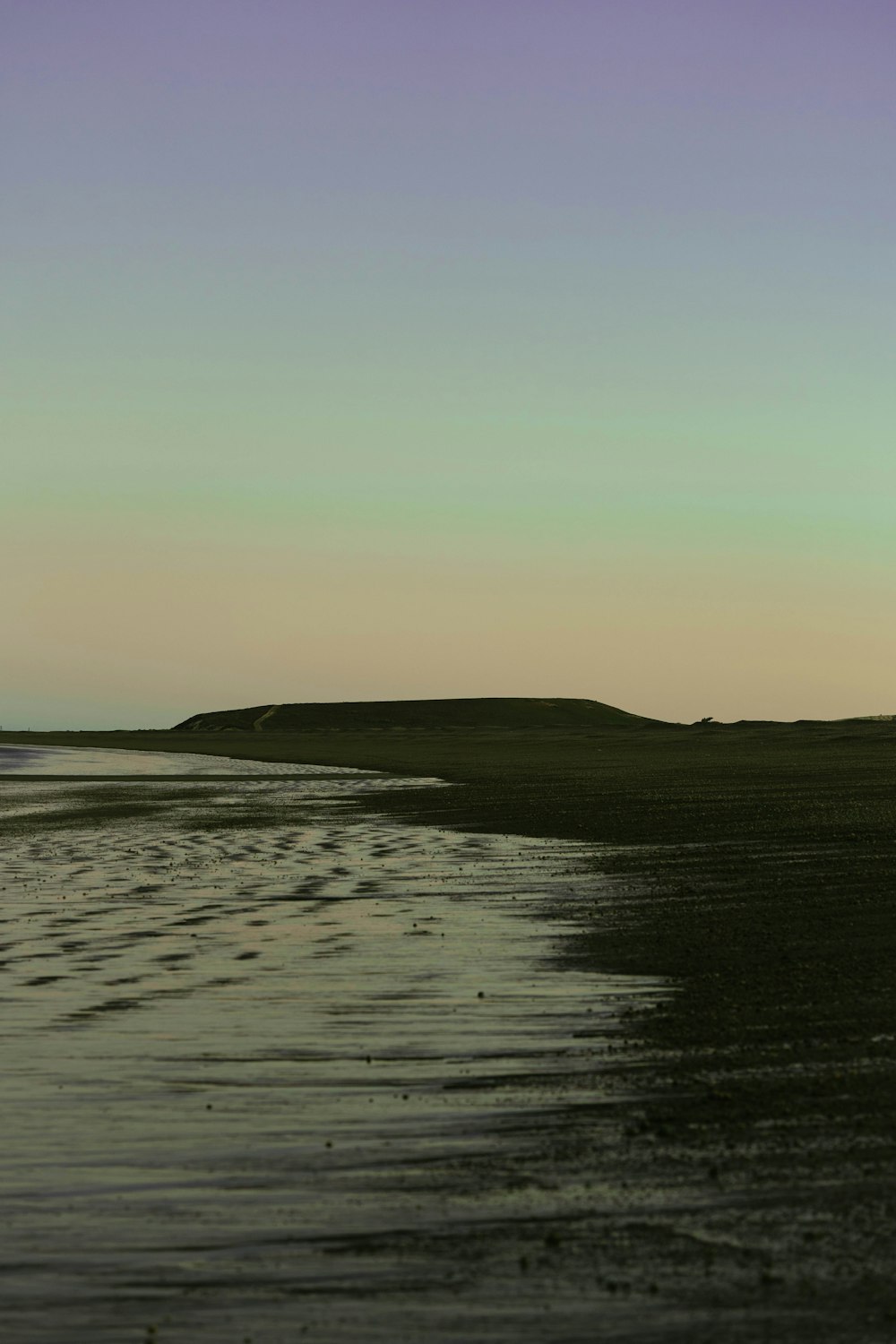 a body of water with hills in the background