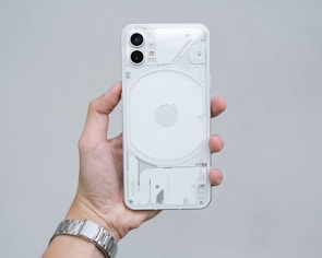 a hand holding a white cell phone