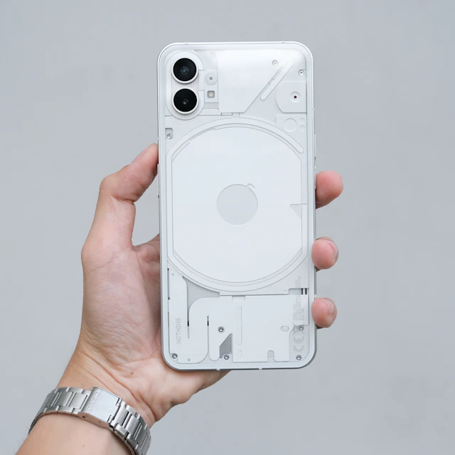 A hand holding a white Nothing Phone (1)