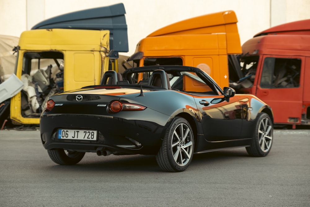 a black sports car parked next to a yellow van