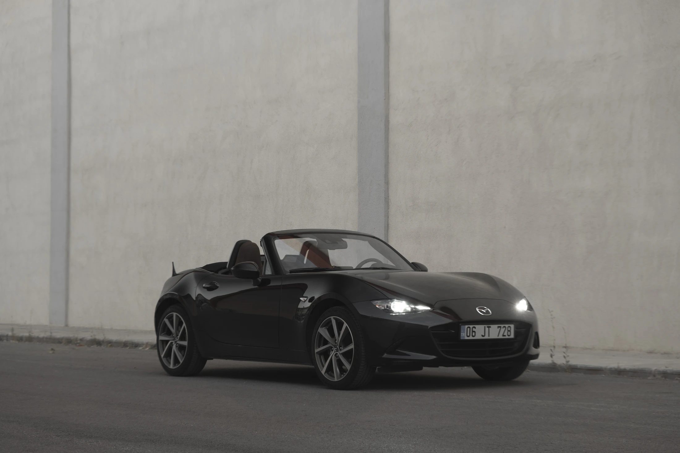 Black Mazda MX-5 ND roadster with the top down