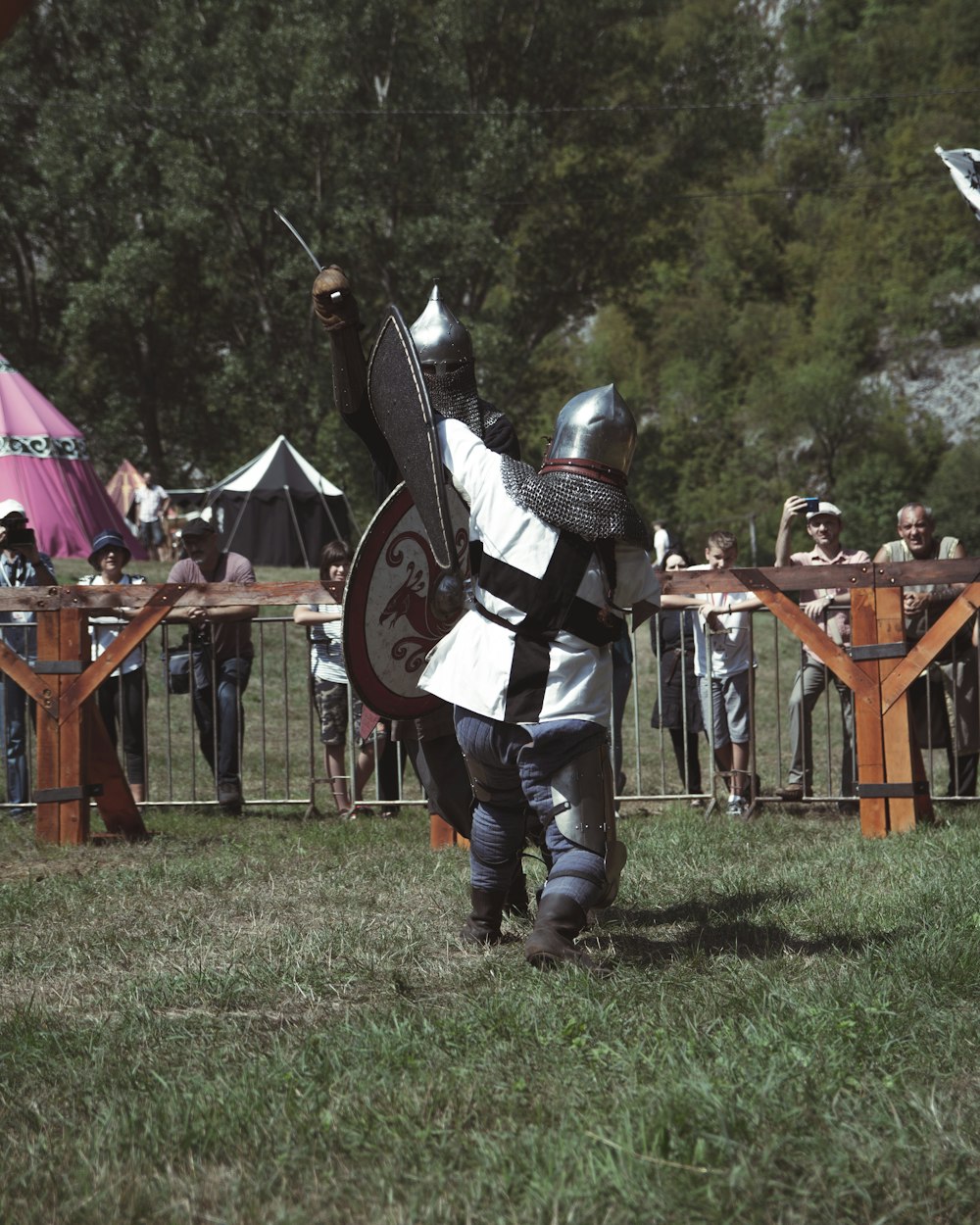 a person in a garment holding a sword in front of a crowd