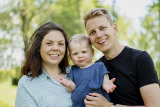 a man and woman holding a baby