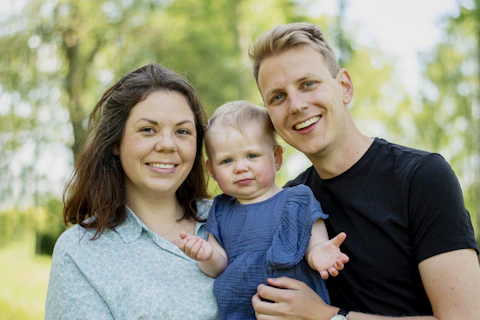 a man and woman holding a baby