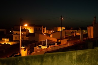 Evening photograph of a completed residential project with warm lights glowing through windows.