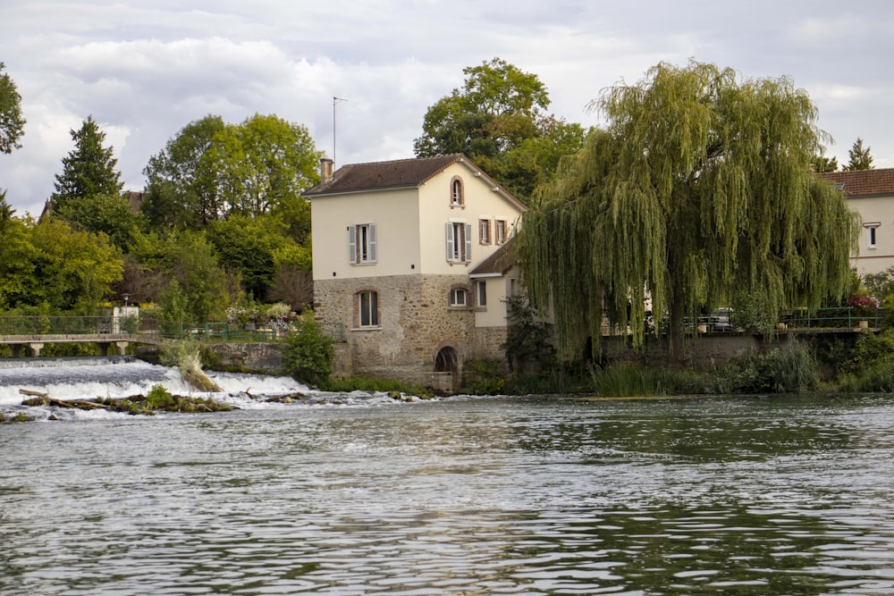 a house on a hill by a river with Slater Mill Historic Site in the background