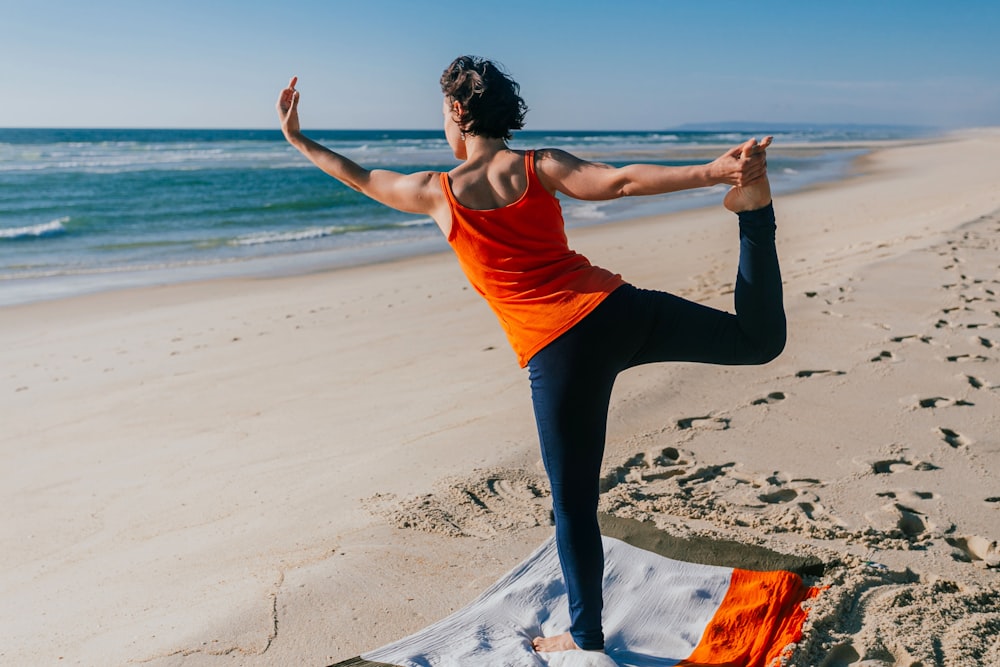 a woman doing yoga on a beach