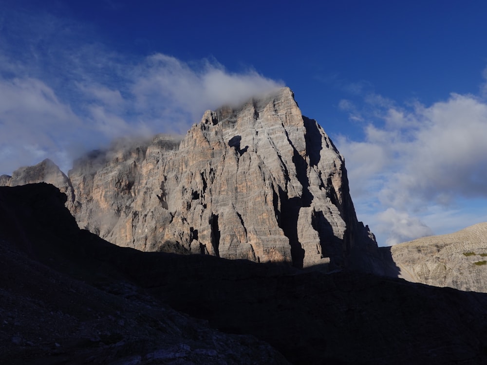 a rocky mountain with a blue sky