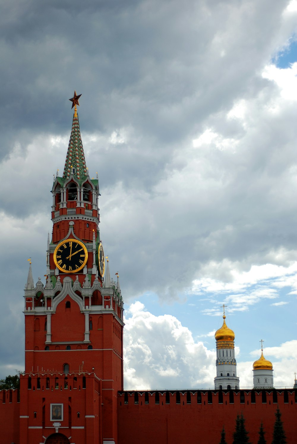 a large building with a clock tower with Moscow Kremlin in the background