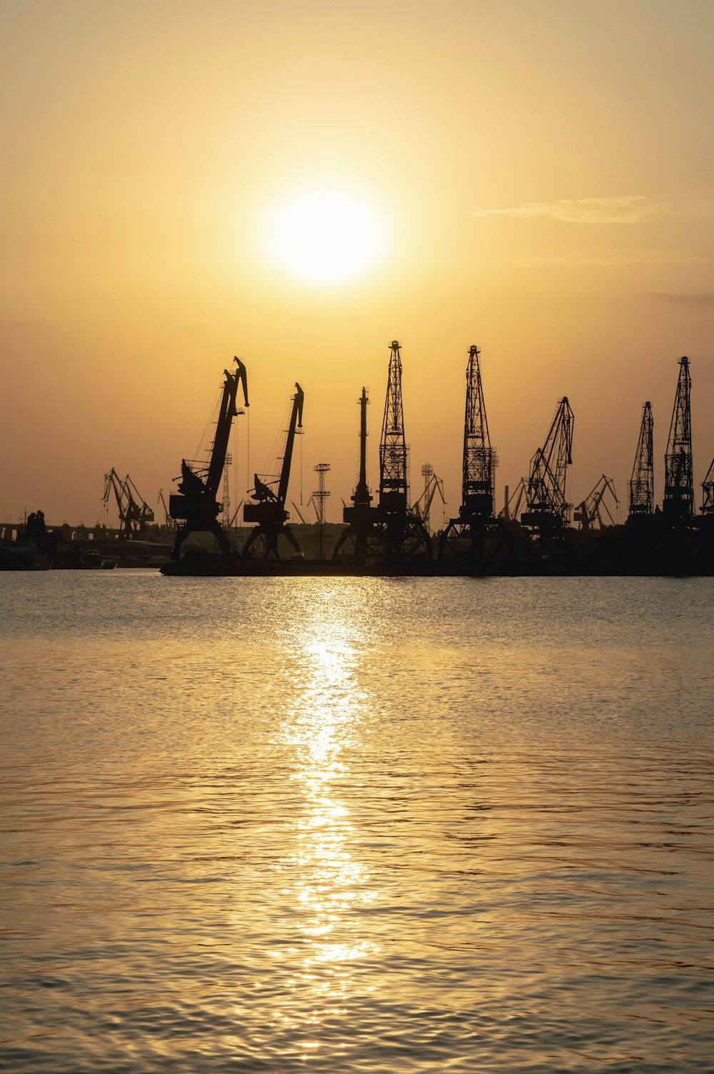 a body of water with many oil rigs in the distance