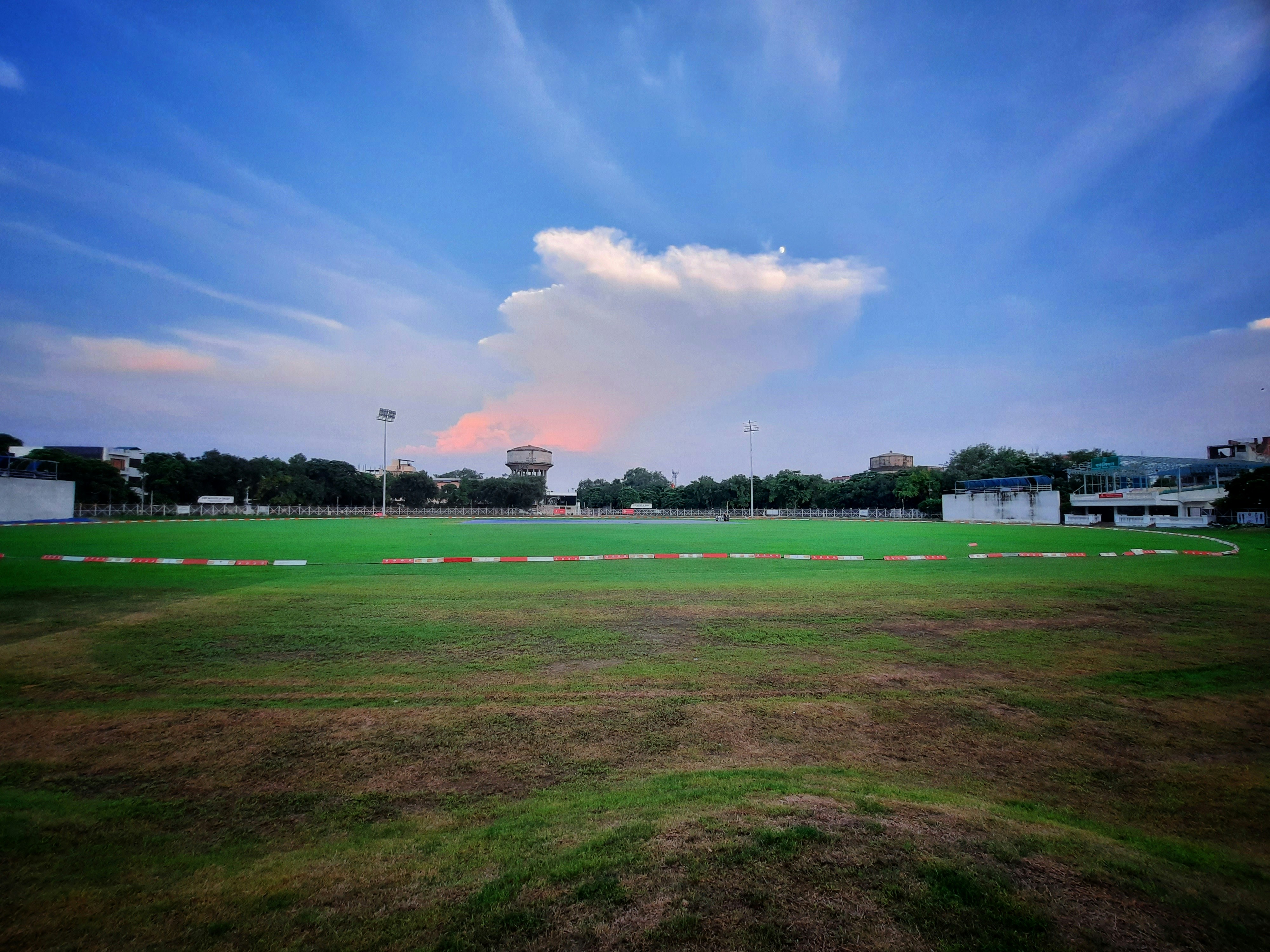 a large open field with a few buildings in the background