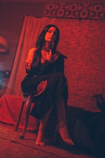 Mysterious dark room setting with crimson and black color scheme highlighting BDSM session ambiance