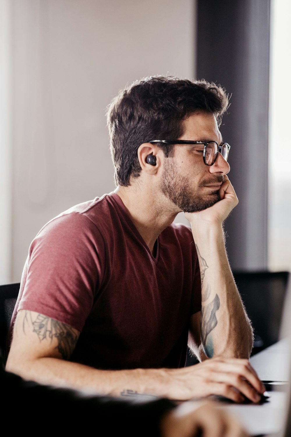 a man with his hand on his chin looking at a computer