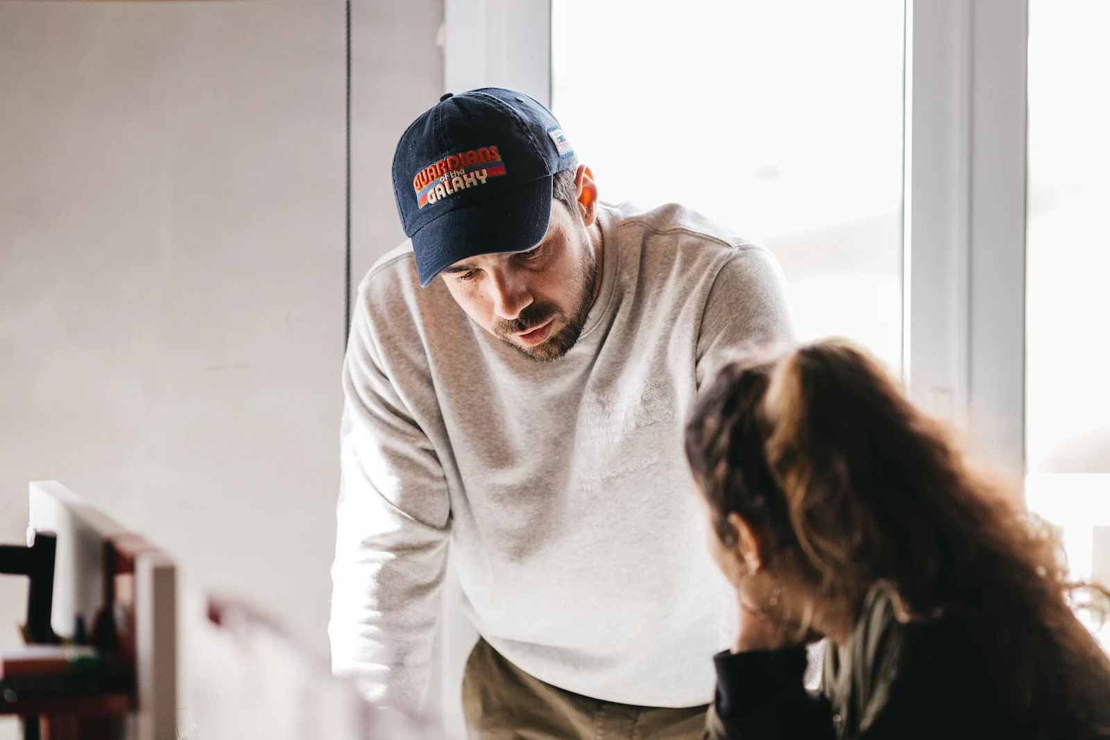 A man and a woman in conversation indoors, representing a family member talking with a respite provider to compare answers across two options