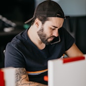 a man with a beard looking at a computer monitor