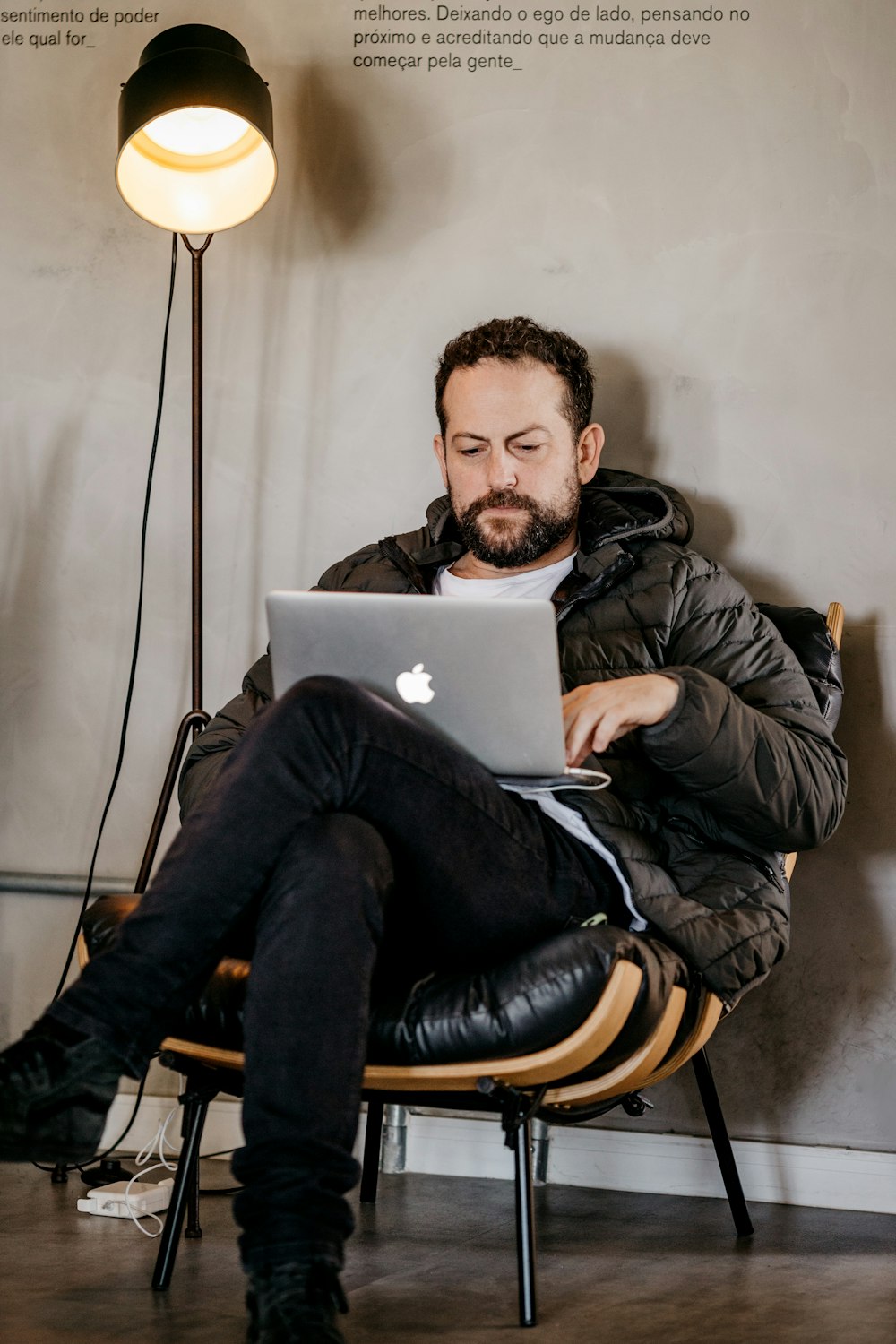 a person sitting in a chair with a laptop