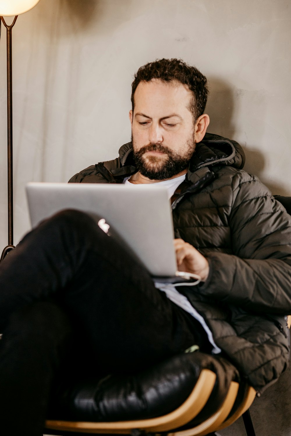 a man sitting in a chair with a laptop