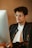 Close-up of a person wearing glasses while working on a laptop.