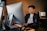 A professional working on a laptop in a modern office environment with multiple monitors.