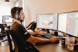 a man wearing headphones and sitting at a desk with a computer
