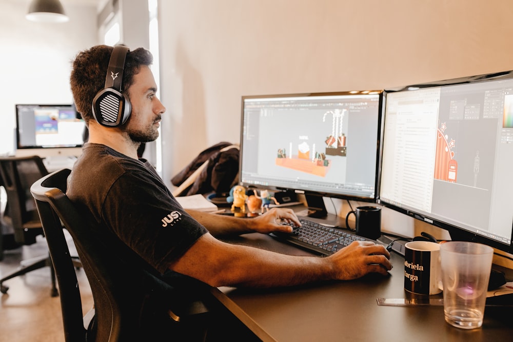 Un hombre con auriculares y sentado en un escritorio con una computadora