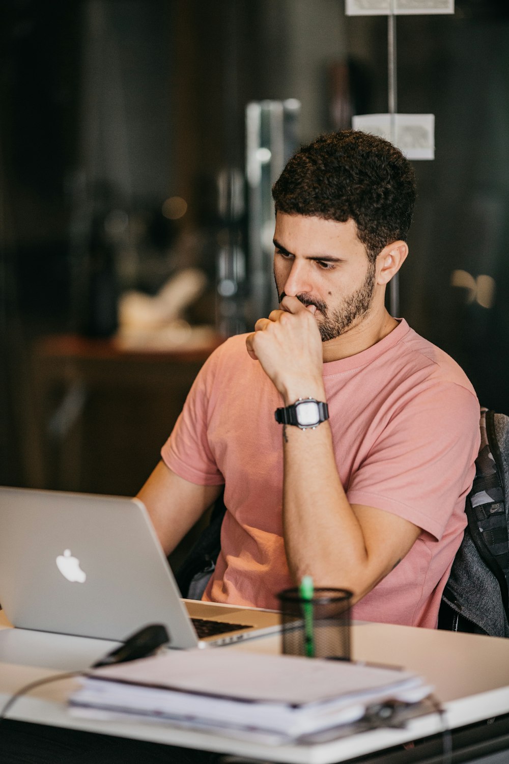 a man sitting at a table with a laptop and a cup