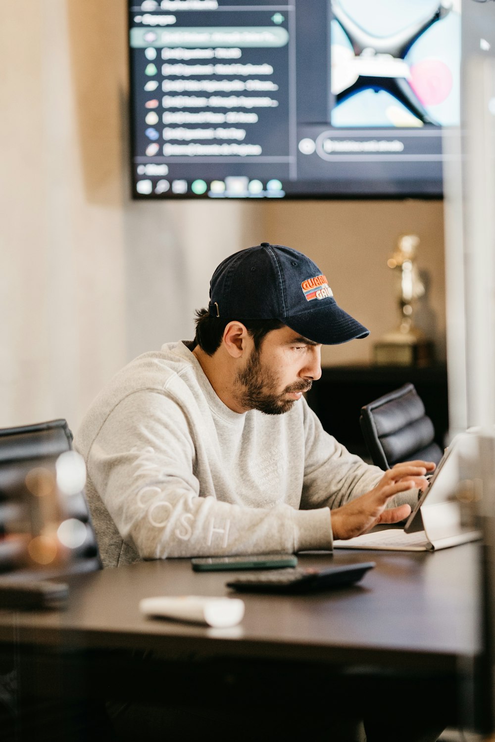 a man in a hat looking at a tablet