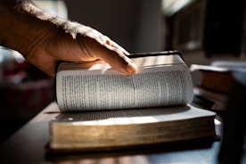 a hand holding a stack of books