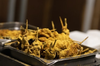 Close-up of assorted kababs sizzling on a grill with vibrant spices.