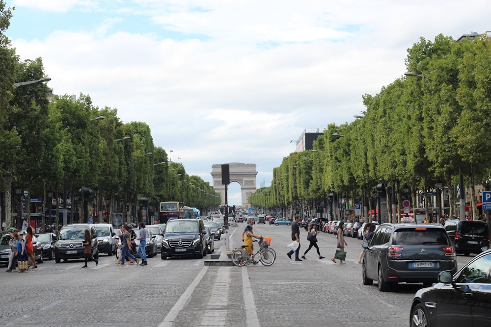 a busy street with cars and people with Champs-Élysées in the background