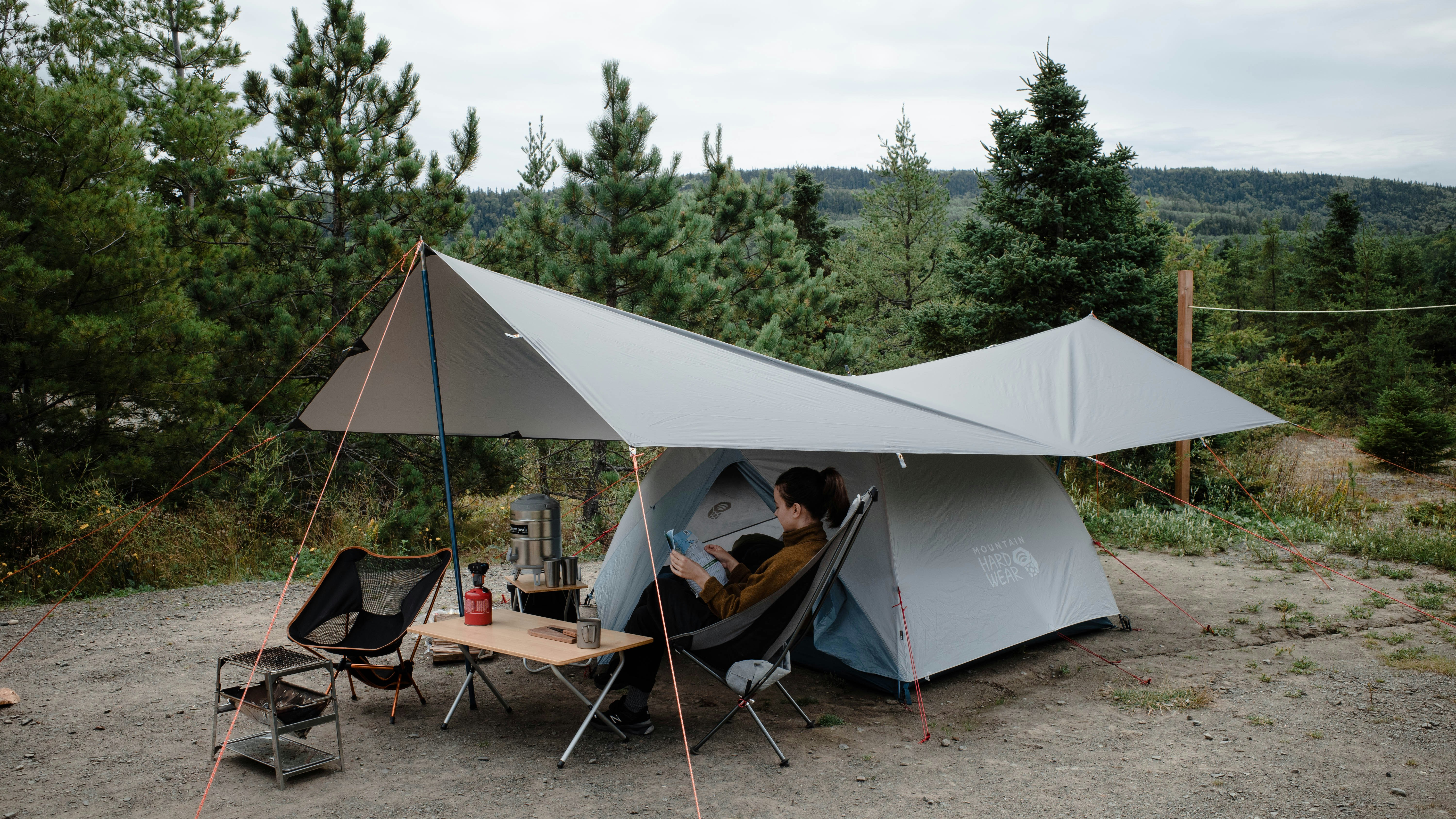 a person sitting in a chair outside of a tent