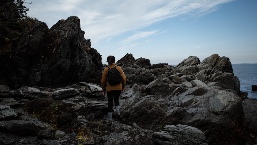 a man walking on a rocky beach