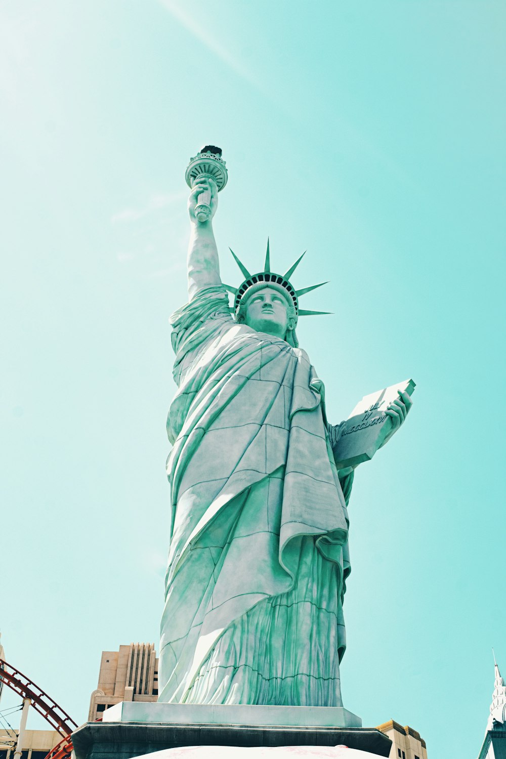 a statue of a person holding a torch with Statue of Liberty in the background