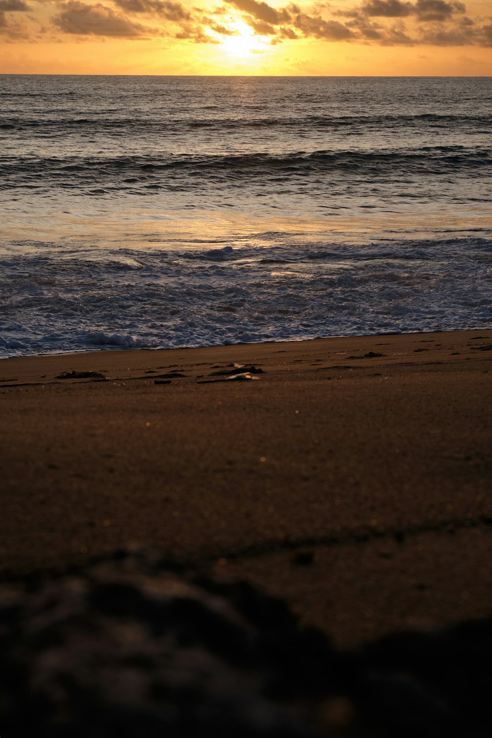 a beach with waves and a sunset