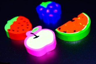 Brightly colored erasers shaped like cartoon characters on a pastel background.