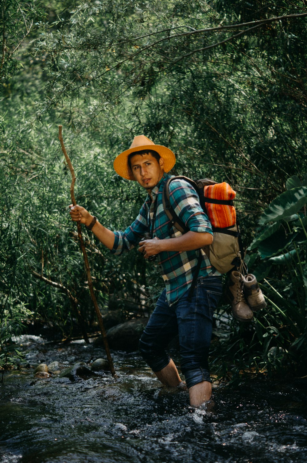 a man holding a stick in a forest