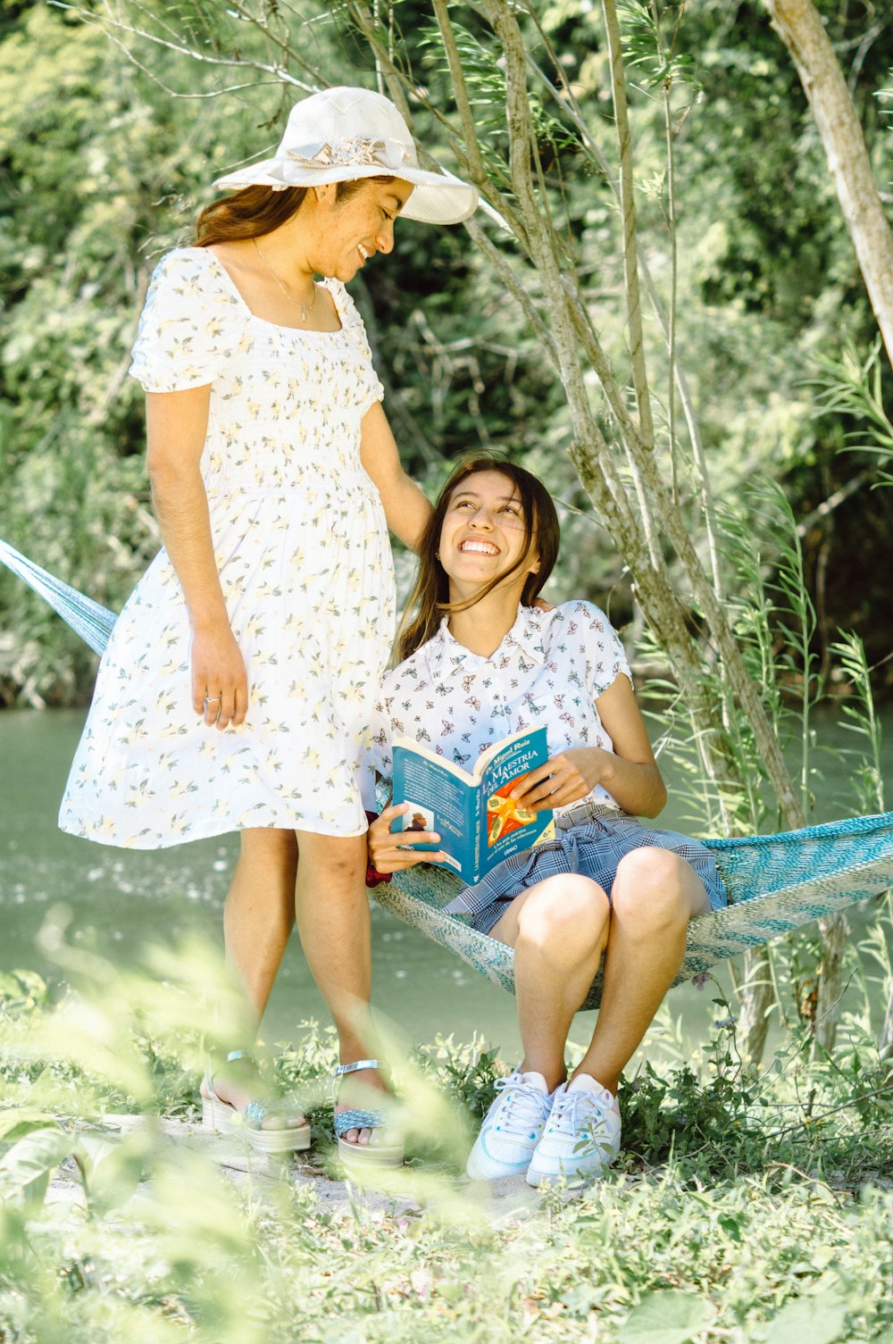 a person and a girl sitting on a bench in a park