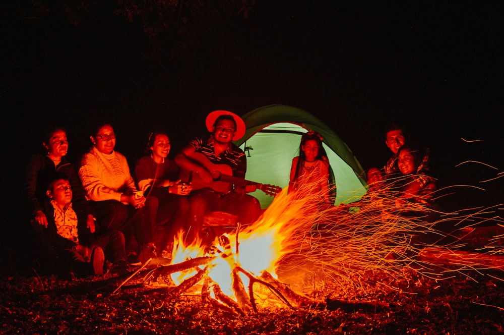 a group of people sitting around a campfire