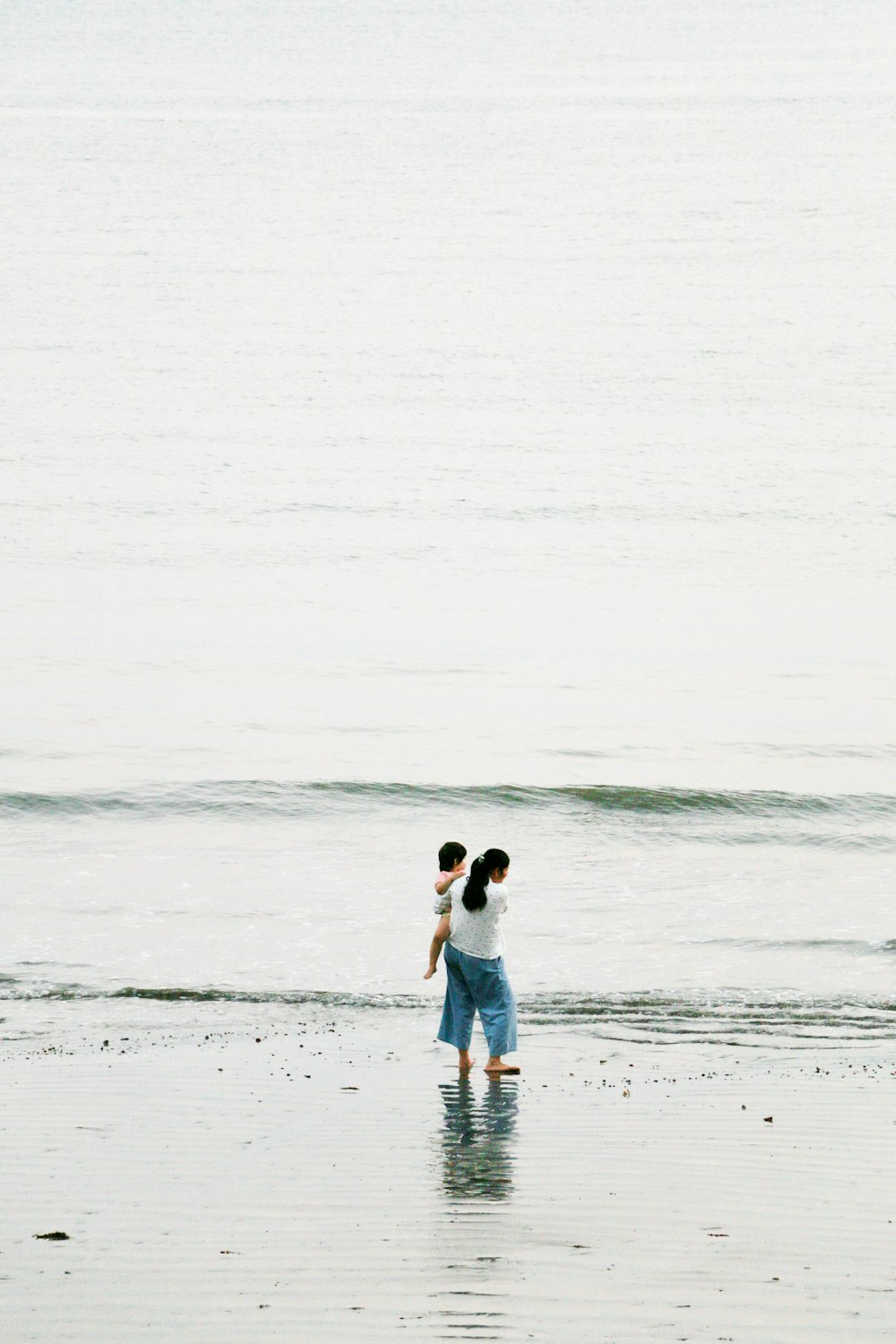 a man and woman kissing on a beach