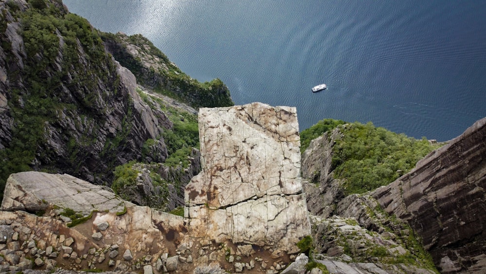 a rocky cliff with a boat in the distance