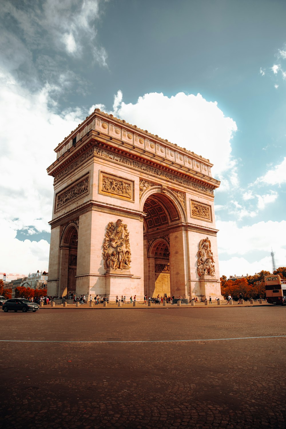 a large stone building with a large archway with Arc de Triomphe in the background