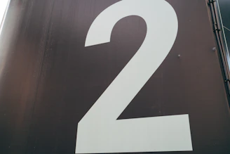 A dark card with a large golden number 02 centered.