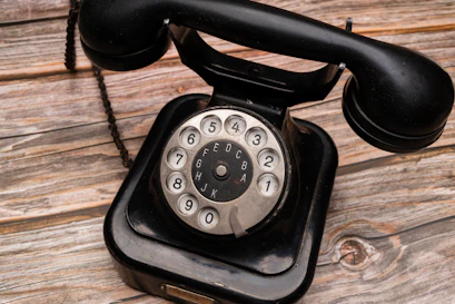 a black telephone on a wooden surface