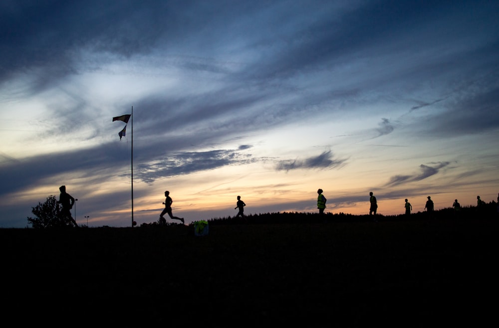 a group of people standing on a hill with a flag and a flag