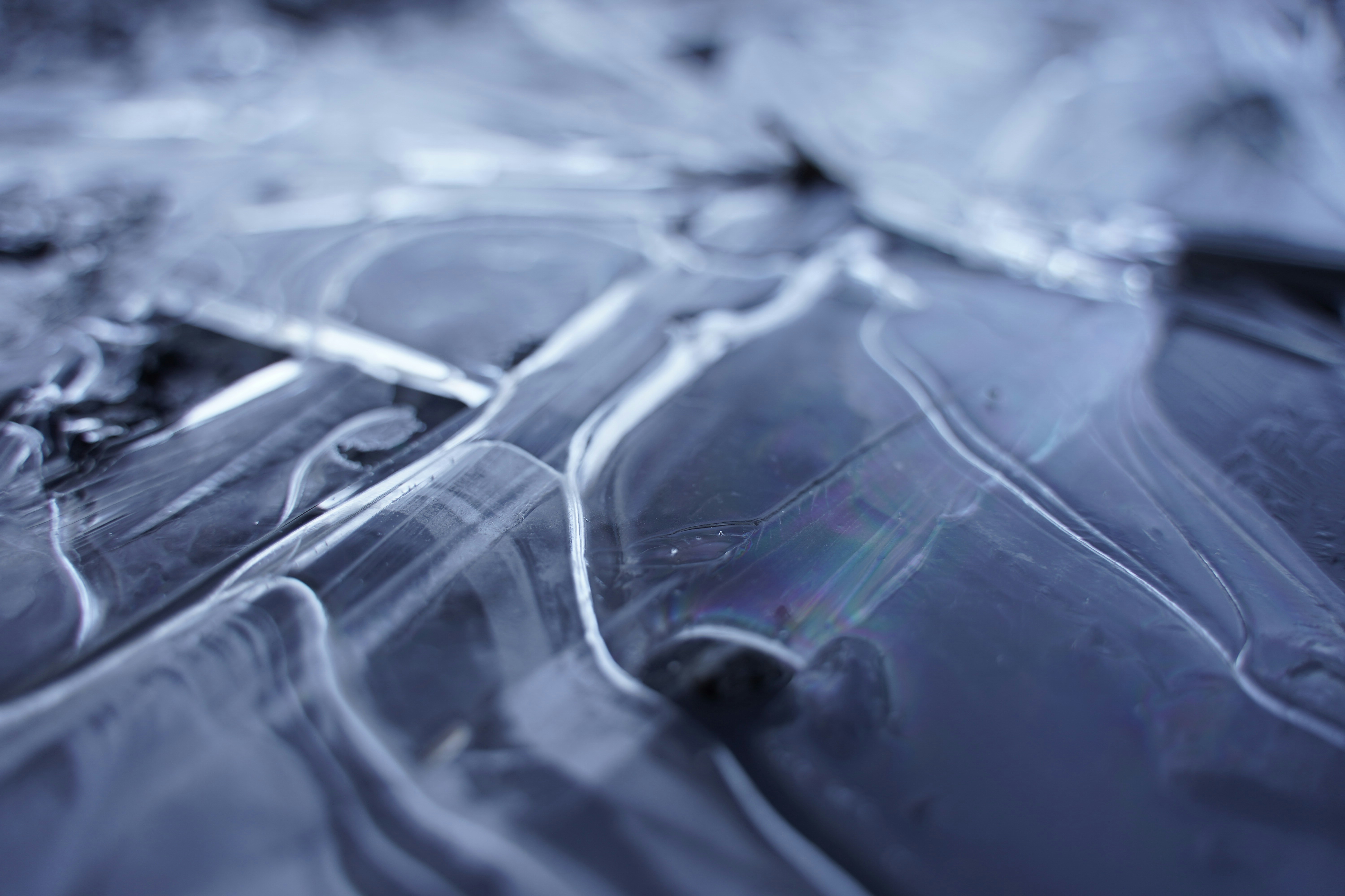Close-up of a frozen puddle with oil film
