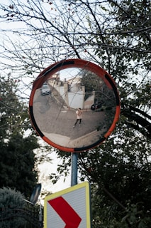 a mirror showing a person walking on a street