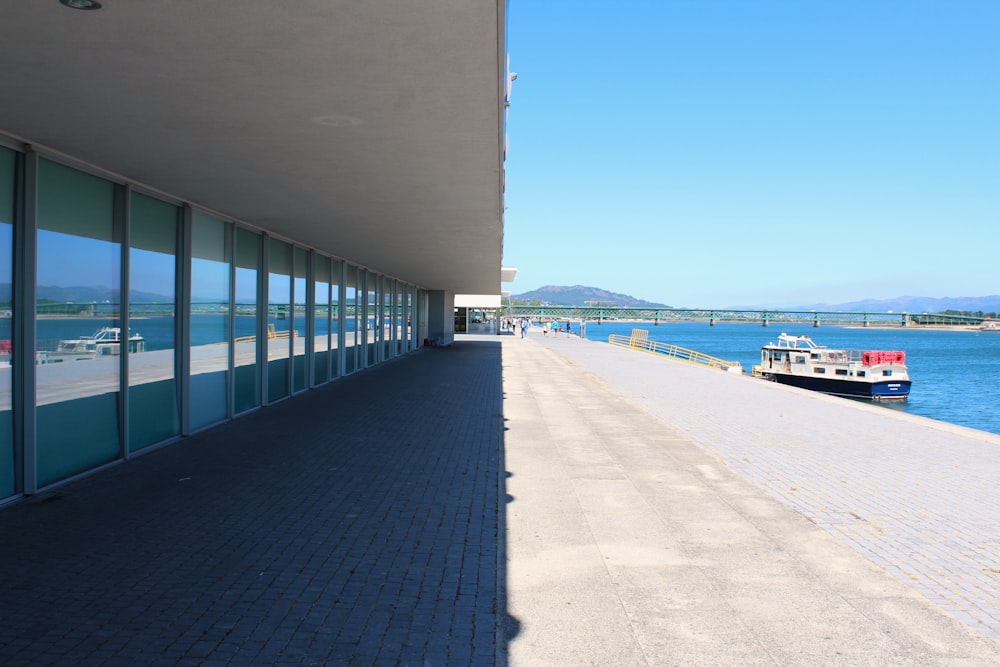 a walkway next to a body of water with a boat in it